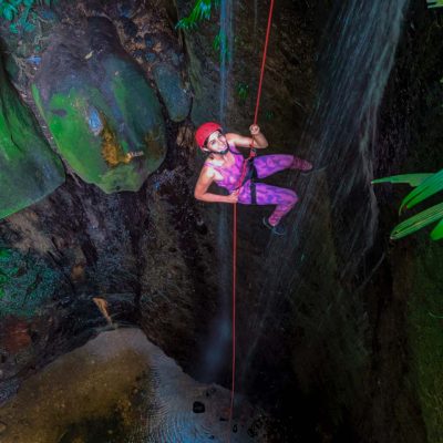 Chica subiendo por la cuerda en una corriente